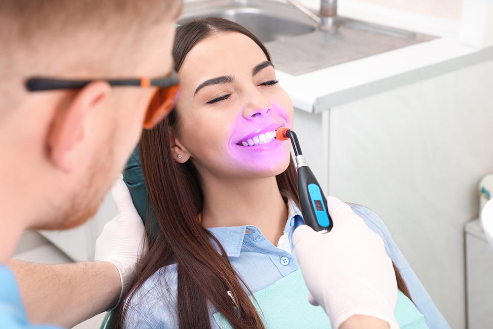 The dentist at AH Dentistry offering cosmetic tooth contouring services to a patient